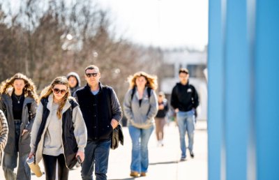 Students and faculty walking across the Allendale campus on a cloudy day.